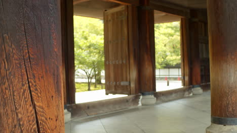 Pilares-Gigantes-De-Un-Gran-Templo,-Entrada-De-Puerta-De-Madera-En-Kyoto,-Iluminación-Suave-De-Japón