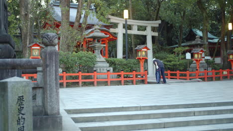 Early-morning-guy-cleaning-a-beautiful-shrine-in-Kyoto,-Japan-soft-lighting