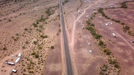 Luftdrohnenansicht,-Die-Fahrzeugen-Auf-Der-Autobahn-Durch-Die-Wüste-Und-Den-Verstreuten-Campingplatz-Folgt---Quarzit-Arizona