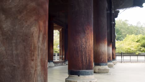 Slide-shot-of-huge-wooden-pillars-in-a-temple-in-Kyoto,-Japan-4K-slow-motion