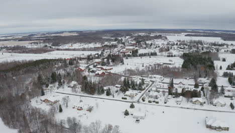 Aerial-view-of-winter-wonderland-rural-town-with-fresh-snow-covering-the-ground