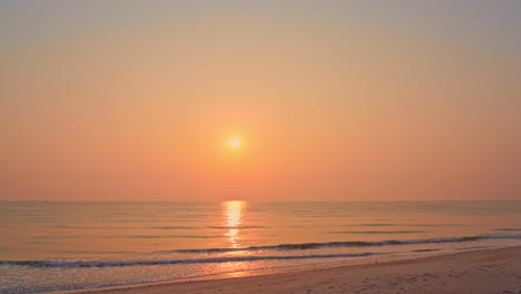 Erstaunliche-Goldene-Sonnenuntergangswellen-Am-Meer,-Die-Langsam-Auf-Den-Sandstrand-In-Bali-Rollen,-Kameraschwenks-Nach-Links