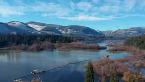 Drone-shot-of-Cowichan-Lake-on-Vancouver-Island-British-Columbia-Canada-overlooking-frosty-mountain-,-lake-and-forest
