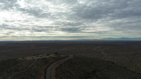 Vista-Aérea-De-Una-Torre-De-Radio-En-La-Cima-De-Una-Montaña-Con-Vistas-Al-Desierto