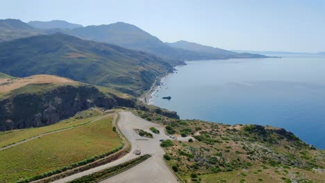 Aerial-shot-flying-over-the-green-mountains-of-Preveli-beach,-on-the-mediterranean-sea