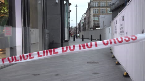 Red-and-white-tape-that-says,-“Police-line,-do-not-cross”-marks-the-cordon-on-a-crime-scene-during-daylight