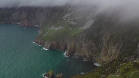 Slieve-League-cliffs-and-rugged-coastline-revealed-through-low-clouds,-aerial