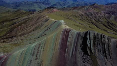 Aerial,-tilt,-drone-shot-overlooking-the-Palcoyo-rainbow-mountain,-in-Valle-Rojo,-or-Red-Valley,-sunny-day,-in-Andes,-Peru,-South-America
