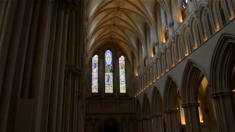 Stunning,-smooth-gliding-shot-looking-down-the-spectacular-nave-towards-the-stained-glass-windows,-inside-Wells-Cathedral,-in-Wells,-England