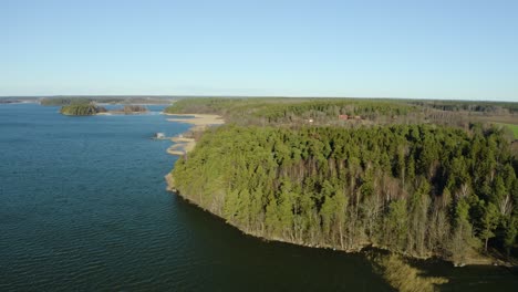 Härjarö-nature-preserve,-lake-Mälaren-in-Sweden,-forested-hills-and-beach-by-the-lake