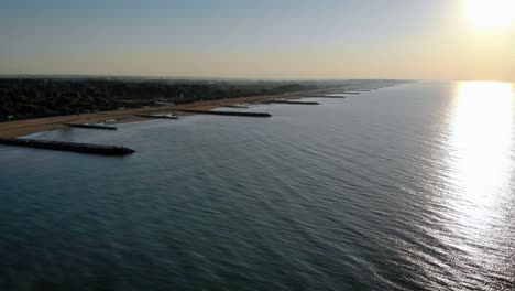 Aerial-over-the-calm-Adriatic-sea-reflecting-the-sun-on-a-beautiful-morning-in-Caorle,-Italy