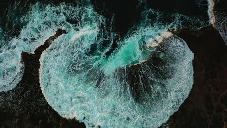 Crashing-blue-waves-breaking-in-abstract-texture-on-shore,-aerial-boom-up,-Oahu