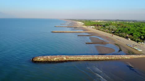 Drone-shot-along-the-beach-and-forests-of-Caorle,-Italy