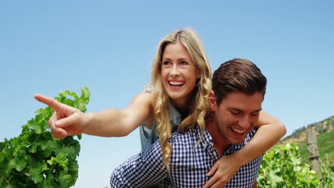 Man-giving-woman-piggy-back-in-vineyard