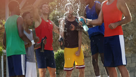 Basketballspieler-Feiern,-Indem-Sie-Sich-Gegenseitig-Mit-Wasser-Bespritzen
