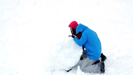 Couple-pushing-a-huge-snowball