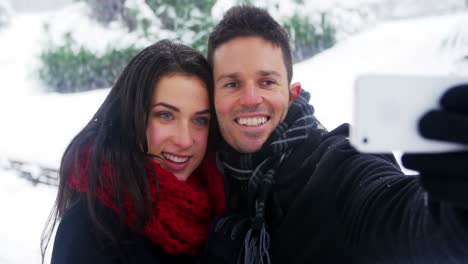 Couple-taking-selfie-on-mobile-phone-during-winter