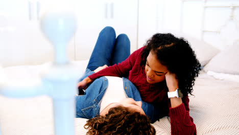 Lesbian-couple-interacting-with-each-other-on-bed