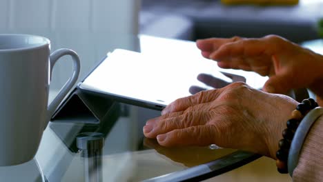 Ältere-Frau-Nutzt-Digitales-Tablet-Im-Wohnzimmer
