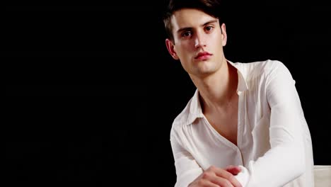 Androgynous-man-posing-against-black-background
