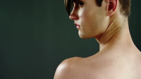 Androgynous-man-posing-against-green-background-background