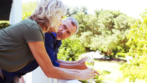 Älteres-Paar-Interagiert-Miteinander,-Während-Es-Auf-Dem-Balkon-Wein-Trinkt
