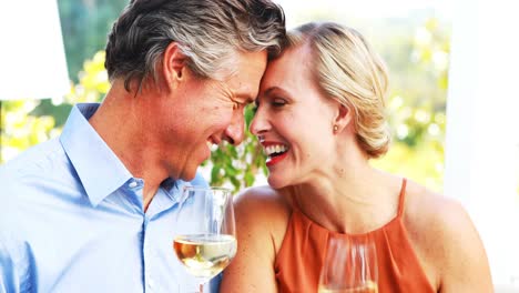 Couple-toasting-wine-glasses-while-having-lunch-in-a-restaurant