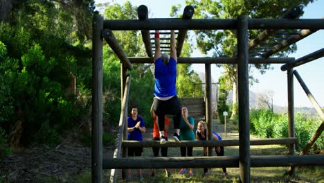 Friends-applauding-woman-while-exercising-on-monkey-bar