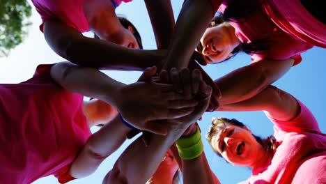 Group-of-women-forming-hand-stack-during-obstacle-course