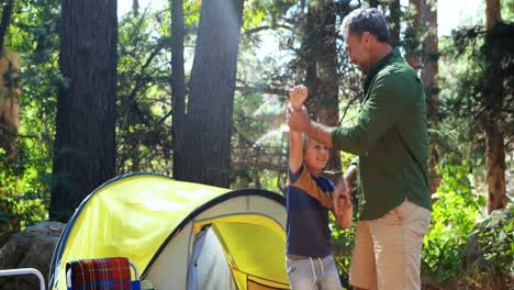 Father-and-son-having-fun-outside-tent
