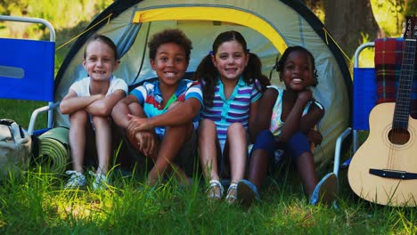 Kids-sitting-outside-tent-at-campsite