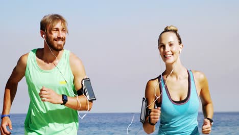 Smiling-couple-jogging-on-the-beach