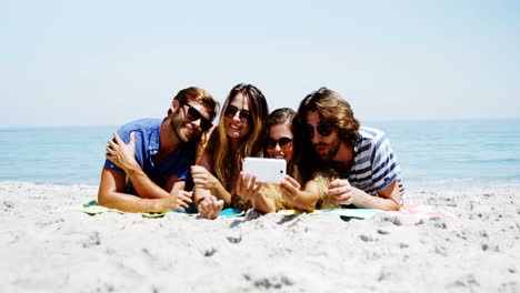 Friends-taking-a-selfie-on-mobile-phone-at-beach