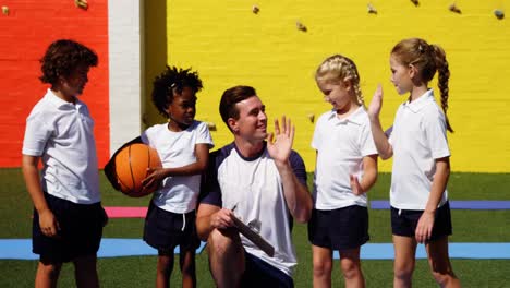 School-kids-giving-high-five-to-coach