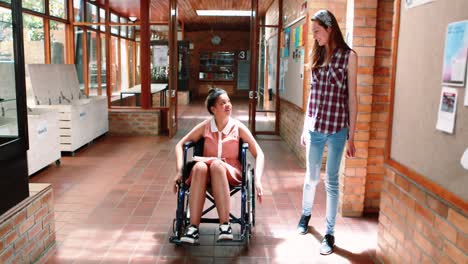 School-girl-interacting-with-her-disabled-friend-in-corridor