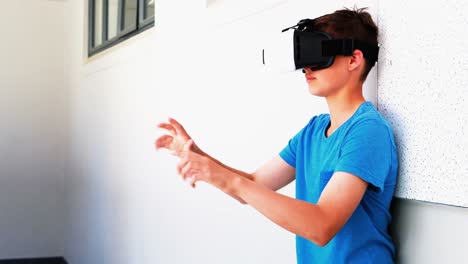 Schoolboy-using-virtual-reality-headset-in-corridor