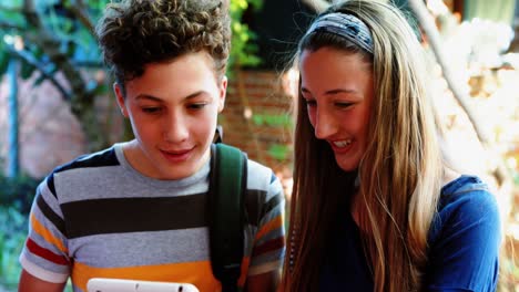 Lächelnde-Schulkinder,-Die-Auf-Dem-Campus-Ein-Digitales-Tablet-Nutzen
