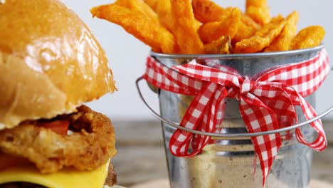 Hamburger-french-with-fries-in-bucket-kept-on-table