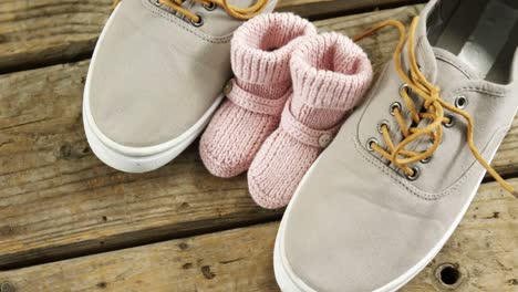 Pairs-of-child-and-fathers-shoes-on-wooden-plank