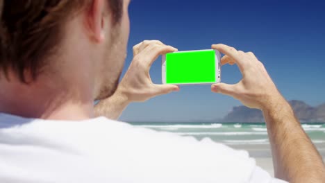 Man-taking-photo-from-mobile-phone-at-beach