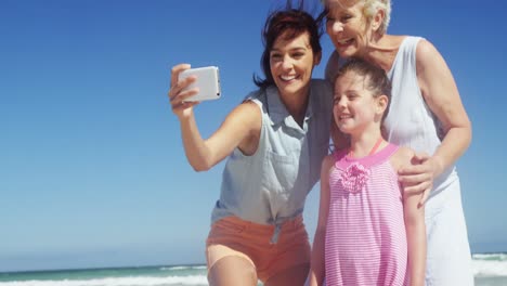 Multi-generation-family-taking-selfie-from-mobile-phone-at-beach