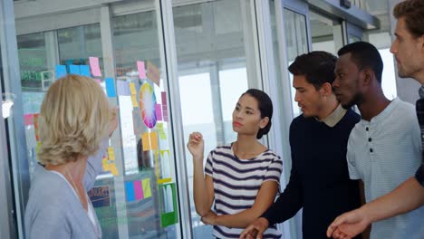 Team-of-executives-discussing-over-sticky-notes