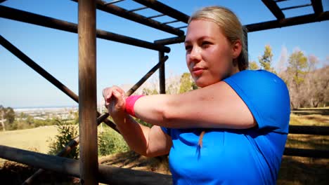 Determined-woman-performing-stretching-exercise-during-obstacle-course