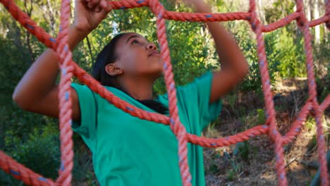 Determined-girl-climbing-a-net-during-obstacle-course