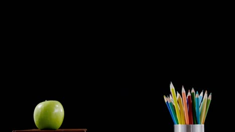 Apfel-Auf-Bücherstapel-Mit-Farbstift-Auf-Dem-Tisch