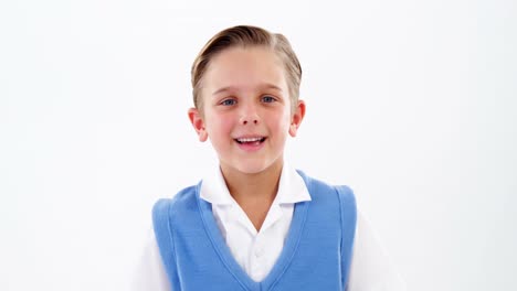 Smiling-schoolboy-standing-against-white-background