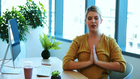 Weibliche-Führungskraft-Macht-Yoga-An-Ihrem-Schreibtisch