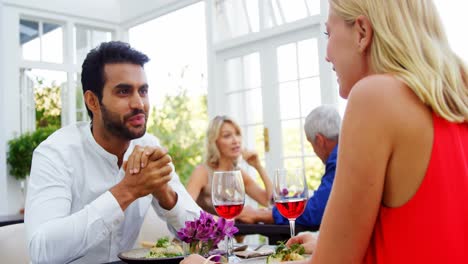 Couple-interacting-while-having-red-wine-in-restaurant