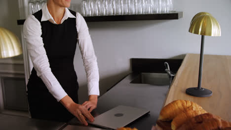 Waitress-walking-with-laptop-at-counter