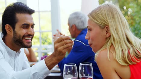 Man-feeding-woman-in-restaurant